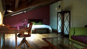 Una stanza con un letto, mobili in legno, un tavolo di vetro e un divano verde.