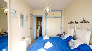 A bedroom with a large bed, a chandelier, a wardrobe, and a mirror. - SUITUR APARTMENT YATE BEACHFRONT FUENGIROLA (Fuengirola)