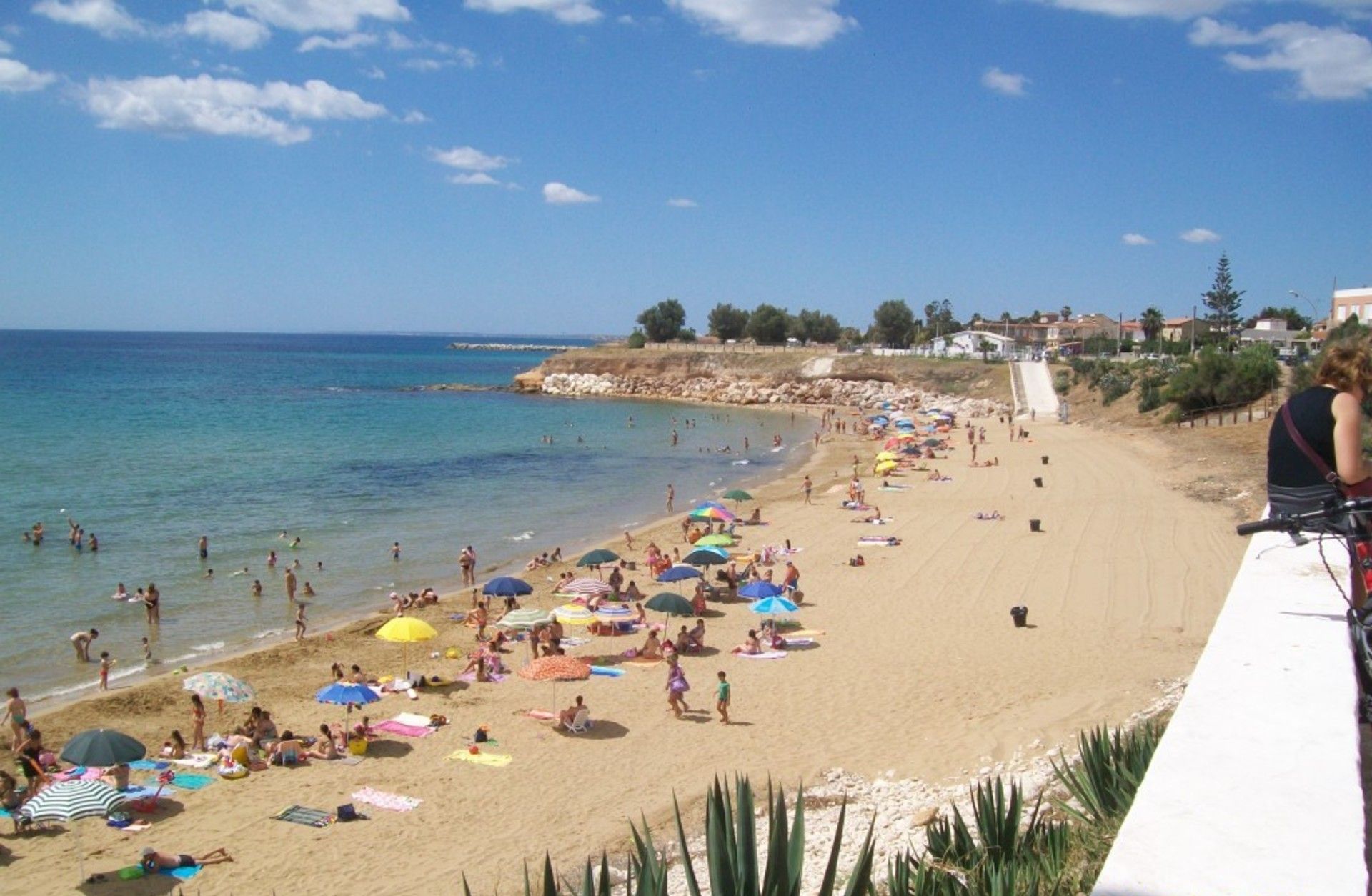 Ein Strand mit Menschen, die sonnenbaden und schwimmen, ein klarer Himmel und ein Stempel mit dem Datum 2015/06/18.