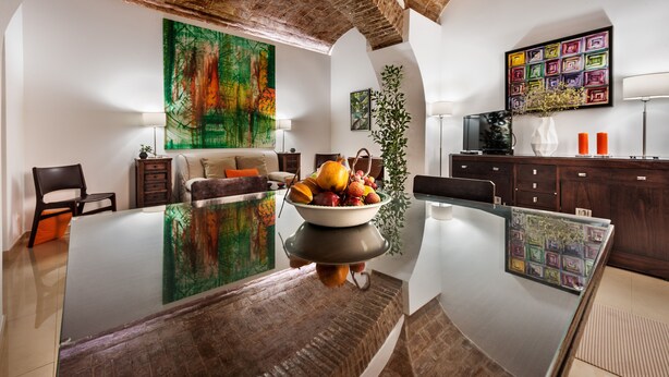 A modern kitchen with a large island, a dining table, and a seating area with a sofa and chairs. - Casa Becco dos Assucares - free GARAGE - Historic Center (Évora)