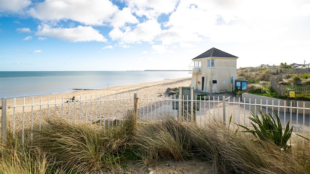 A beach house with a fenced area, a small building, and a view of the beach and ocean. - Seaview Apartment, Silversands, Rosslare Strand, Co. Wexford (Rosslare STrand)