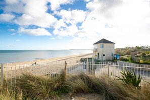 A beach house with a fenced area, a small building, and a view of the beach and ocean. - Seaview Apartment, Silversands, Rosslare Strand, Co. Wexford (Rosslare STrand)
