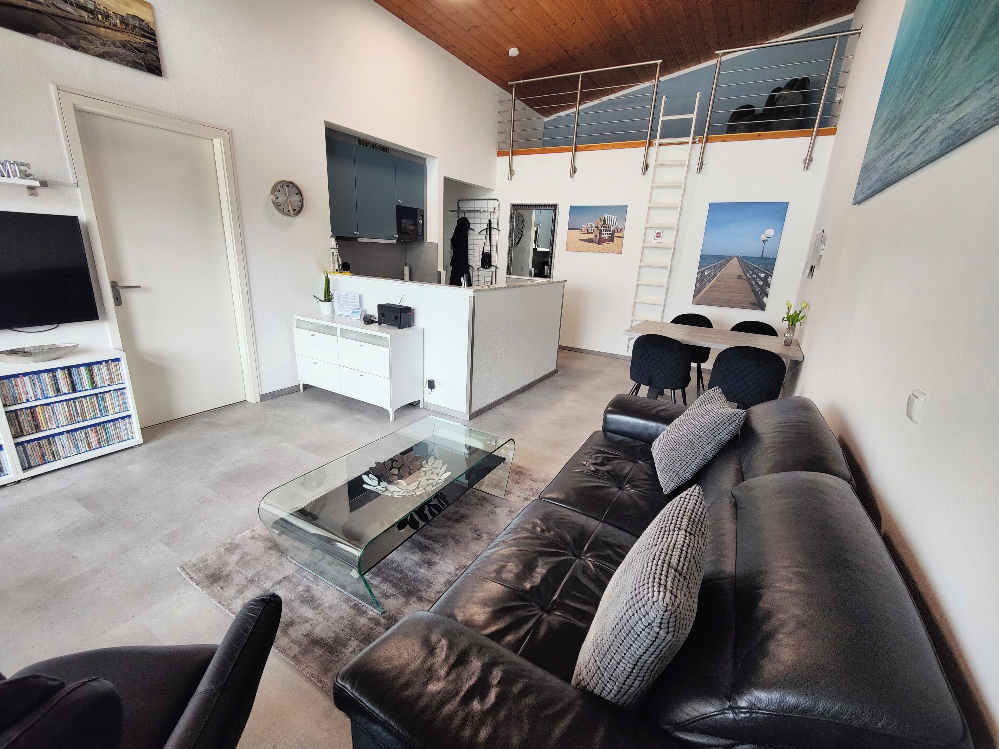 Ein modernes Wohnzimmer mit einer Ledersofa, einem Glastisch und einem Flachbildfernseher.