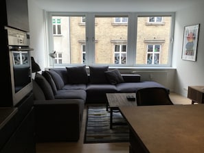 Relax in a compact living space with a large window offering a view of the city.