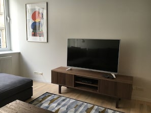 Relax in this stylish living room with a flat-screen TV, comfortable sofa, and beautiful artwork.