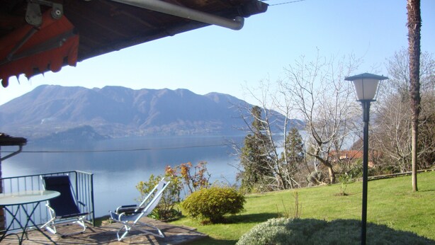 A patio with a table and chairs, a lamp post, and a view of mountains and a lake. - HOUSE OF CHARACTER LAKE MAJOR  (Oggebbio)