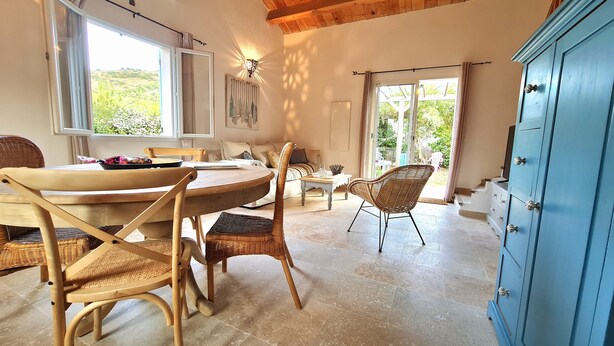 A dining area with a round table, wicker chairs, and a blue cabinet. - Brand new villa, fully equipped, 1.86 miles away from Palombaggia beach (Porto-Vecchio)
