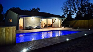 A house with a swimming pool, an outdoor patio, and a covered area with a table and chairs. - Cap-Ferret peninsula: Beautiful villa with heated pool (Lège-Cap-Ferret)