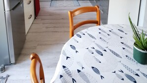 Eine moderne Küche mit roter Akzentwand, Edelstahlgeräten und einem Essbereich mit gemustertem Tischlein.