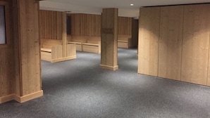 Quarto com paredes de painel de madeira, carpete cinza e um grande guarda-roupa de madeira.