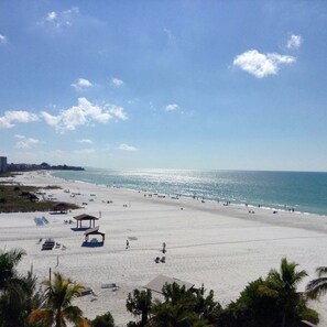 A beach with clear skies, a sandy shore, and a few beach umbrellas. - Unit 68- 1 Bedroom and 1 Bathroom Condominium with Partial South Views. (Sarasota)