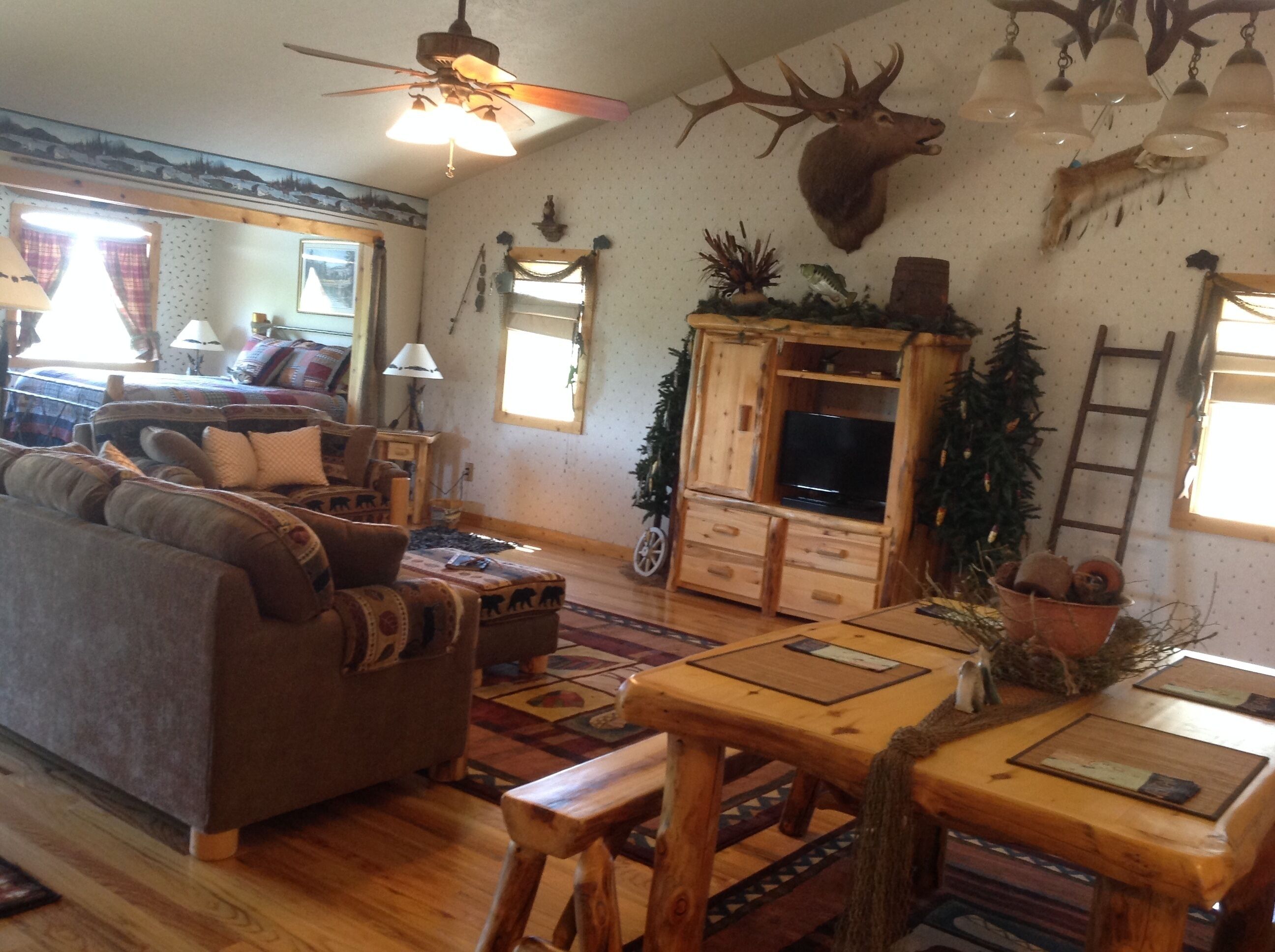 A cozy living room with a sofa, wooden coffee table, and a mounted deer head.