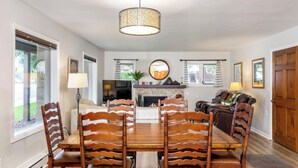 A dining area with a wooden table and chairs, a fireplace, and a television. - All Seasons | A1B - All Seasons 2 Bedroom Platinum (Vail)
