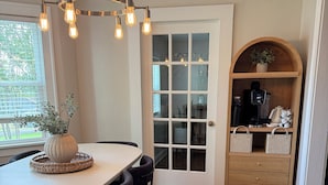 A dining area with a white table, dark chairs, and a hanging light fixture. - Beautiful home near the Augusta National (Augusta)