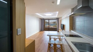 Una cocina moderna con un ventanal grande, un comedor con sillas de madera y vista a un cuerpo de agua.