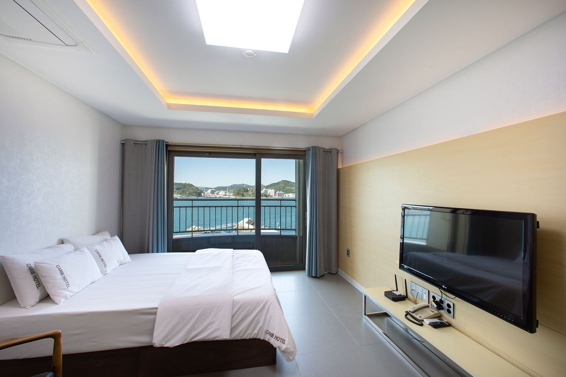 Una camera d'hotel con un letto, una TV e vista mare.