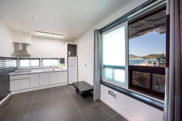 Uma cozinha moderna com uma grande janela que oferece vista para o mar e barcos.