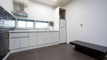 Uma cozinha moderna com forno embutido, geladeira e um banco.