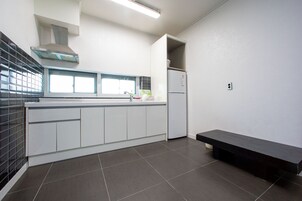 Uma cozinha moderna com forno embutido, geladeira e um banco.