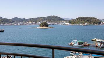 A coastal view with a small island, boats, and a marina.