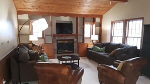 A cozy living room with leather sofas, a coffee table, and a fireplace. - Fantastic Large Home Right On Beautiful Lake Pepin!   (Lake City)