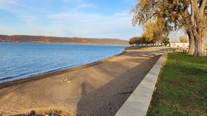 A lakeside walkway with a concrete path, pebbles, and a grassy area. - Fantastic Large Home Right On Beautiful Lake Pepin!   (Lake City)