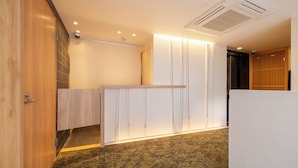A hotel room with a wooden door, a white partition, and a patterned carpet. - RESI STAY Hachi Inn (Kyoto)