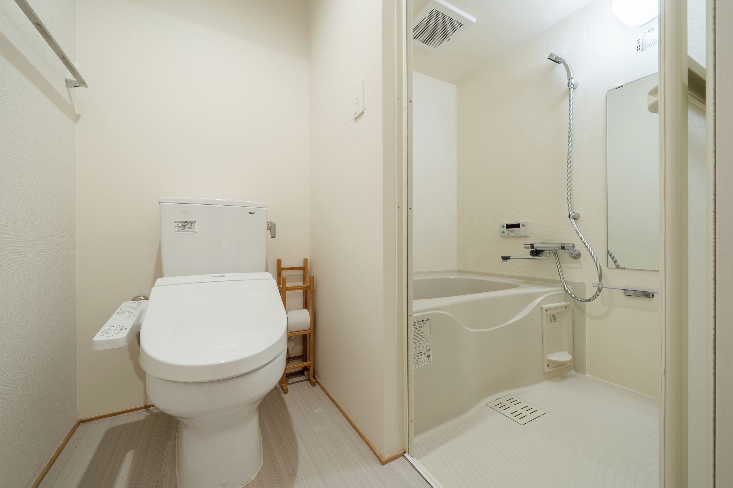 A small, modern bathroom with a toilet, a shower, and a bathtub.
