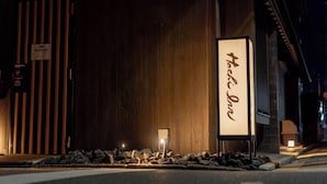 A wooden building facade with a sign reading "Main Entrance" and another sign with "Machi" written on it. - RESI STAY Hachi Inn (Kyoto)