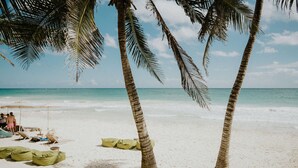 Ein Strand mit Palmen, einem sandigen Ufer und blauem Himmel.