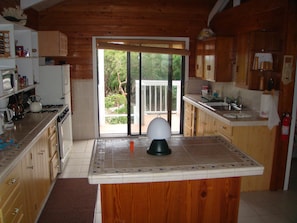 Enjoy cooking in this well-equipped kitchen with an oven and stovetop, and access to an outdoor area with a view.