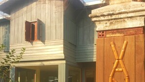 Un bâtiment en bois avec une fenêtre visible et une clôture en bois à l’avant.