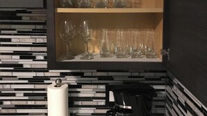 A kitchen with a built-in cabinet containing wine glasses and a coffee maker on the counter. - Newly renovated with lots of upgrades. (Portage)