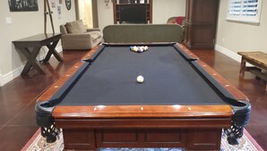 A pool table with a ball, a sofa, and a television in a living room. - Great Sandy apartment with hot tub and pool table! (Sandy)