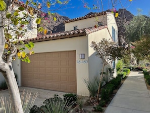 A residential house with a garage, a clear sky, and a mountain in the background. - The Artisan Villa | 3BR Legacy Villa (La Quinta)