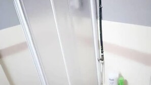 Un baño con inodoro, ducha y dispensador de papel higiénico.