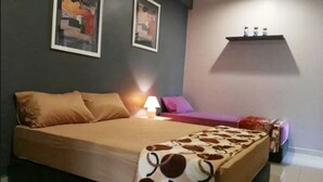 Une chambre à coucher avec un grand lit, une table de chevet avec une lampe et deux tableaux encadrés au mur.