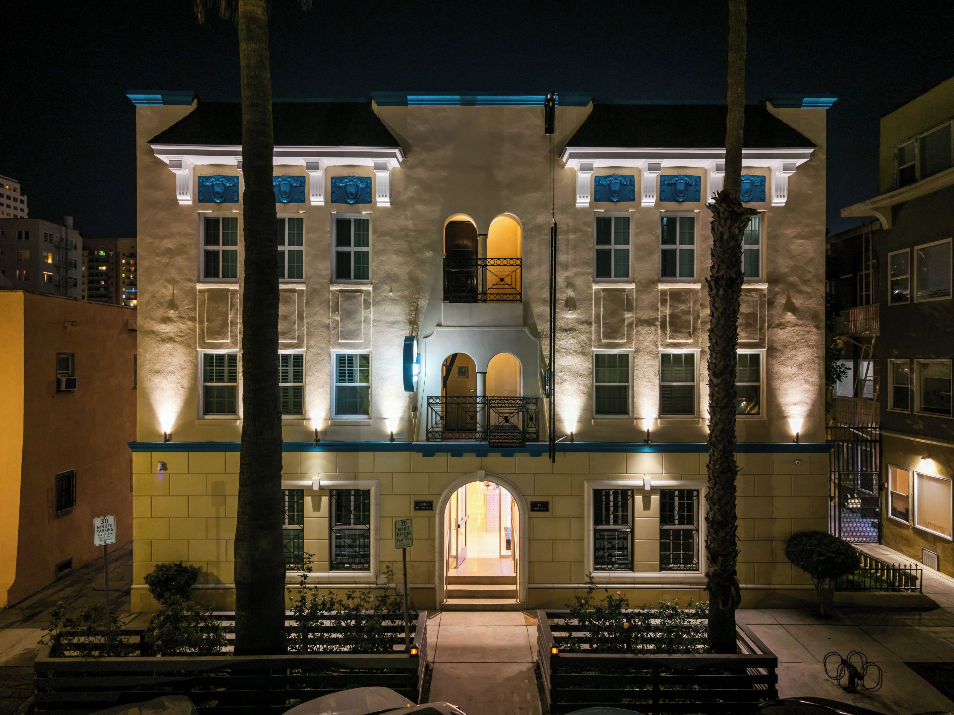 A multi-story building with a central entrance, large windows, and a balcony on the second floor.