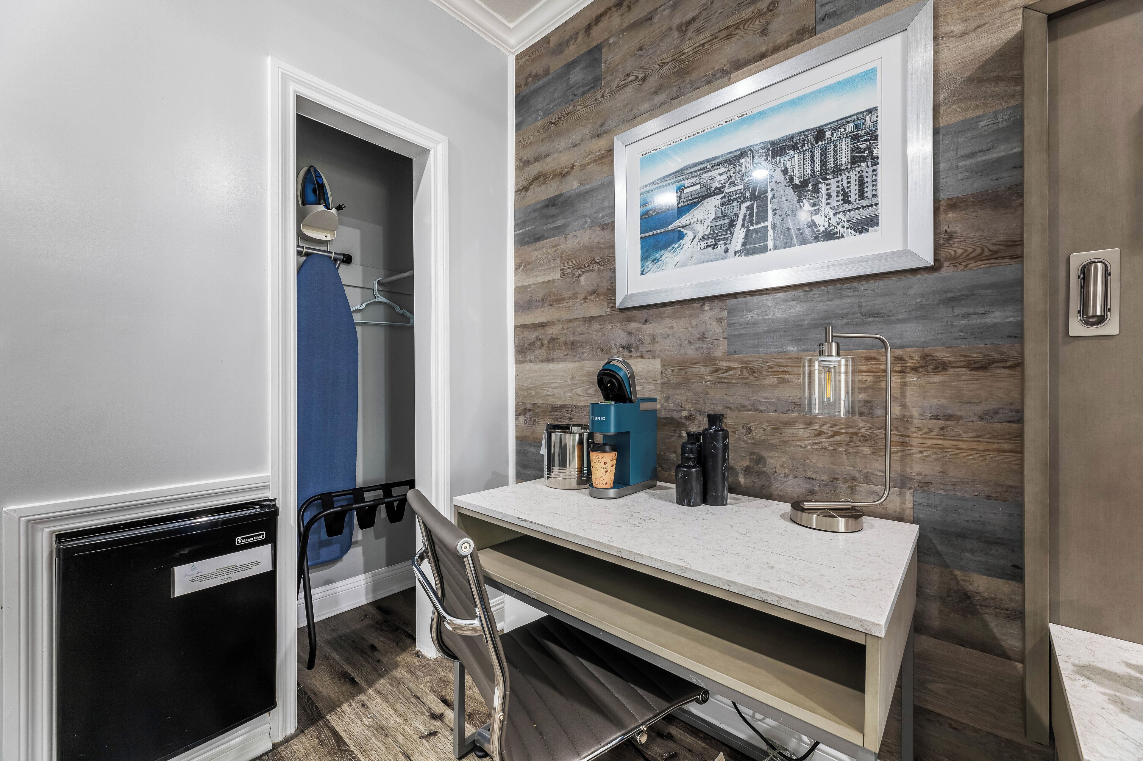 Una kitchenette compacta con refrigerador incorporado, cafetera y lavamanos.