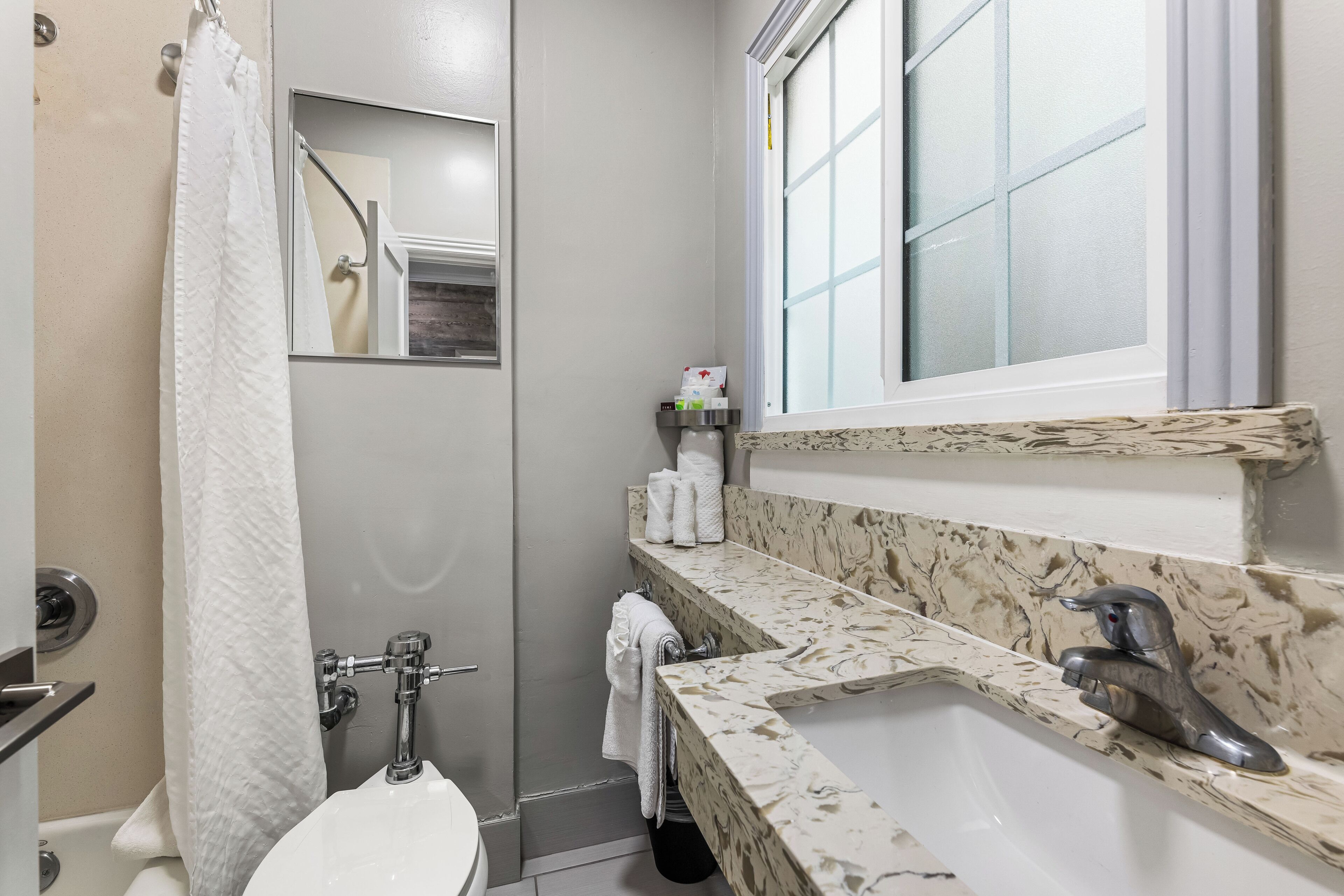 A bathroom with a toilet, sink, and shower.