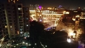 Nachtsicht auf ein Hotel mit Schwimmbad, mehreren Etagen und beleuchteten Gebäuden.