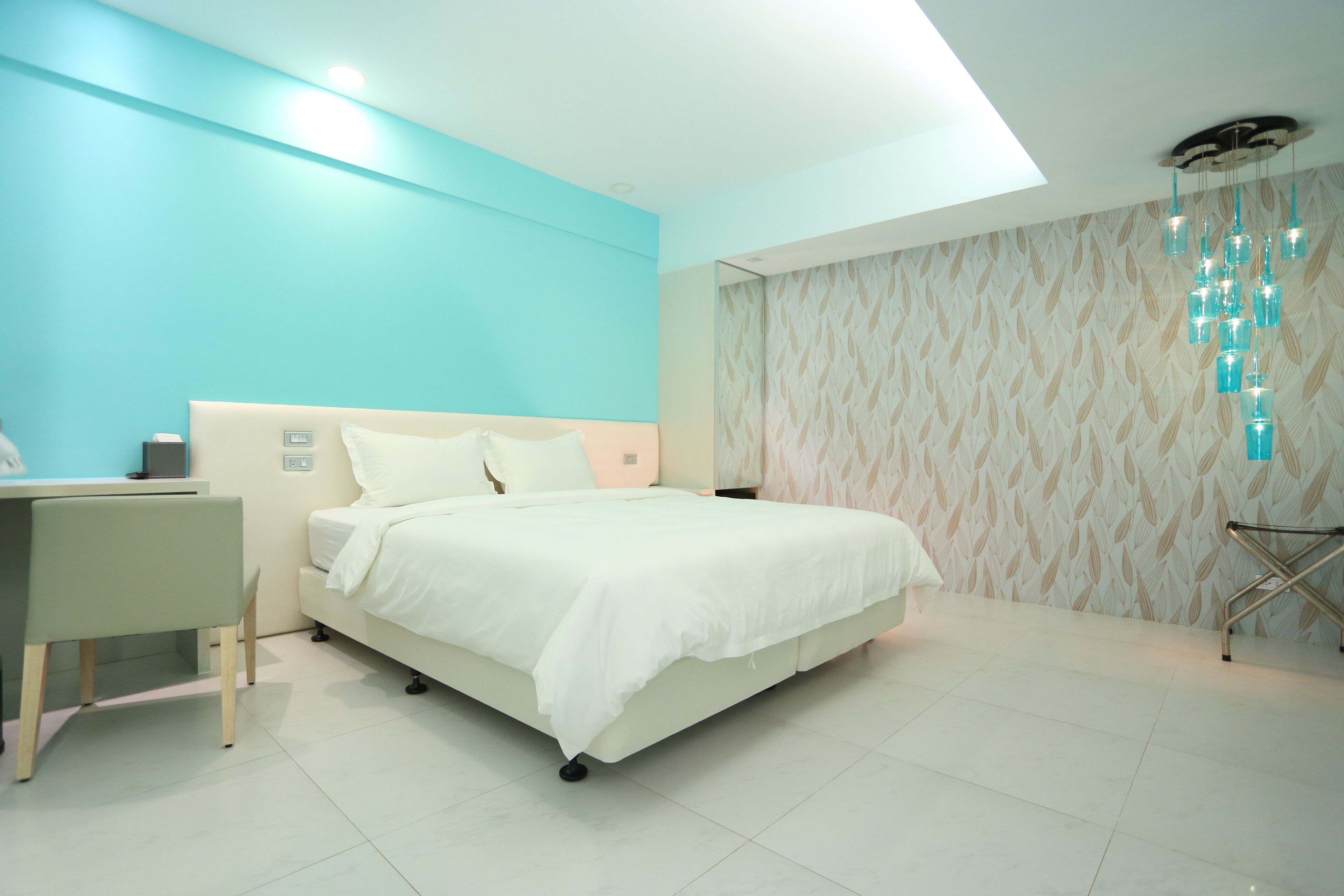 Un dormitorio moderno con cama, escritorio y silla.