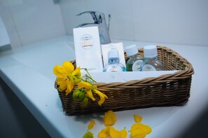 A wicker basket with toiletries and a card on a bathroom counter. - Udawalawe Ayurvedic Resort (Rankethgama)