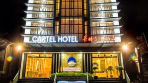 Het exterieur van Hotel Cartel 's nachts, met een modern ontwerp, verlichte ramen en een opvallende entree.