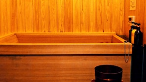 A wooden sauna with a bench and a small stool with a bucket. - K's Villa Hida-an (Takayama)