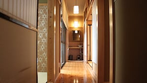 A narrow hallway with wooden flooring and a ceiling light fixture. - K's Villa Hida-an (Takayama)