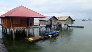 Overwater bungalows met houten constructies en een aangemeerd bootje.