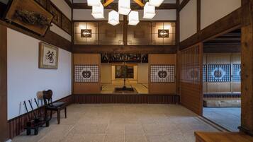 A traditional Japanese room with tatami flooring, a low wooden table, and a hanging lantern.