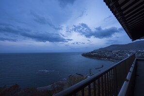 Vista costera desde un balcón con vistas a un pueblo y al mar.