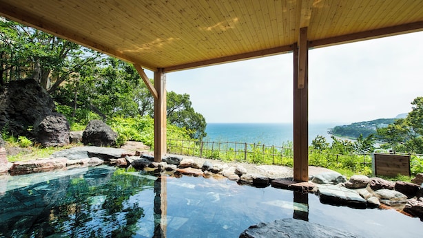 An infinity pool with a wooden deck and a view of the ocean. - Ginrinsou (Otaru)